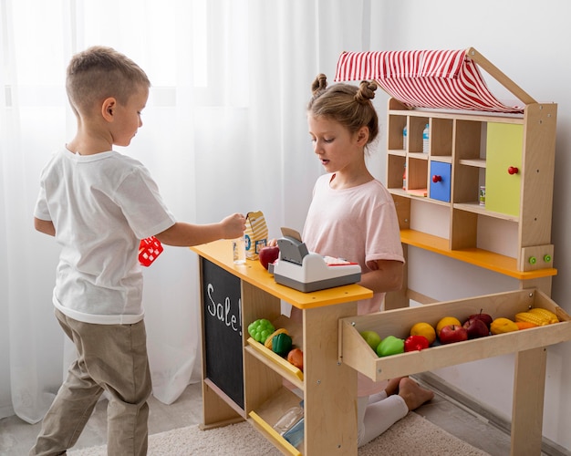 Foto niños no binarios jugando juntos en interiores