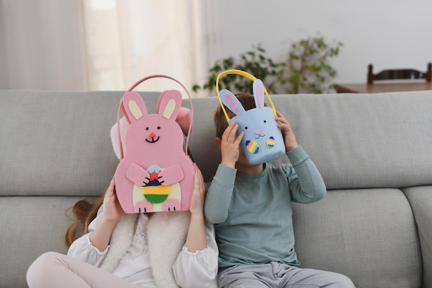 Niños con orejas de conejo y canasta para huevos de chocolate Pascua