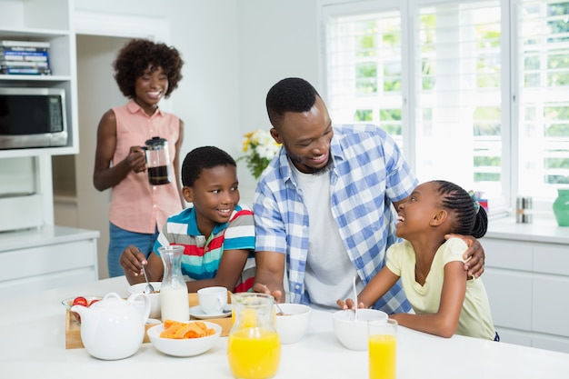 Niños y padres desayunando en la mesa en casa