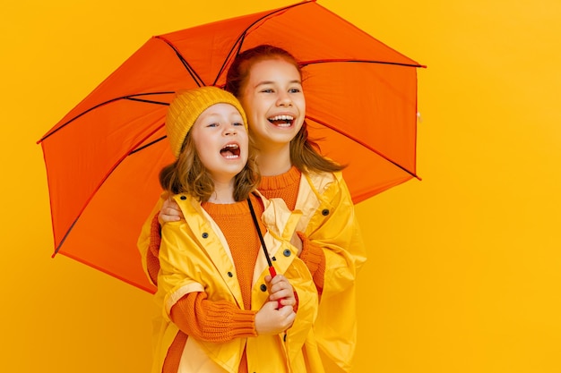 Niños con paraguas sobre fondo de color