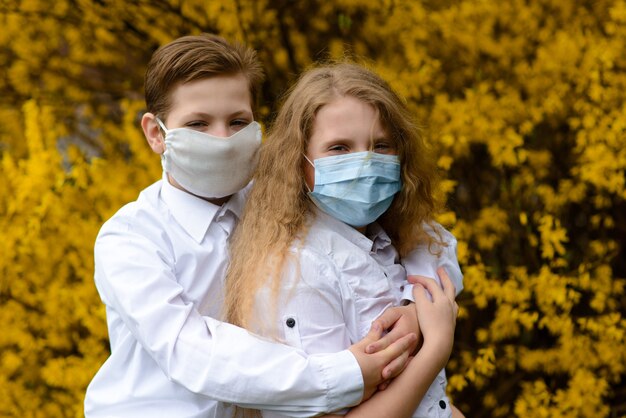 Niños en un parque de la ciudad con una máscara médica durante el período de cuarentena del coronavirus