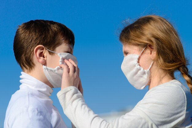 Niños en un parque de la ciudad con una máscara médica.