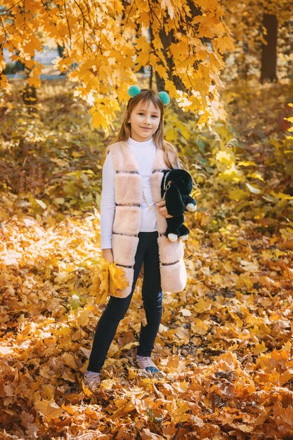 Niños en el parque con hojas de otoño. Enfoque selectivo.