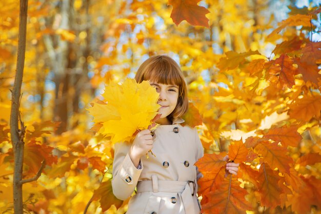 Niños en el parque con hojas de otoño. Enfoque selectivo.