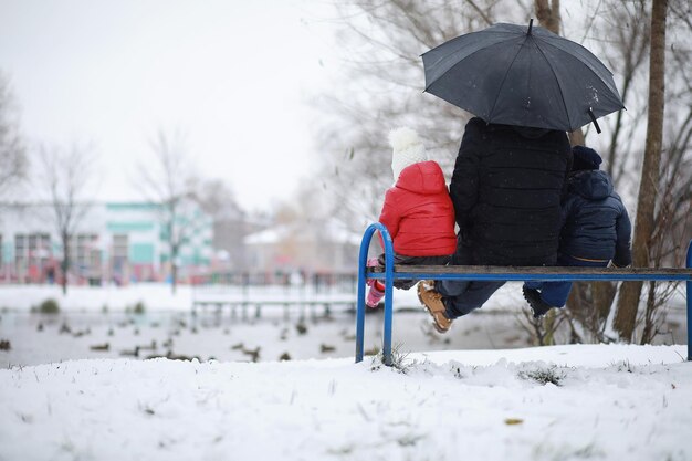 Los niños en el parque de invierno juegan con nieve.