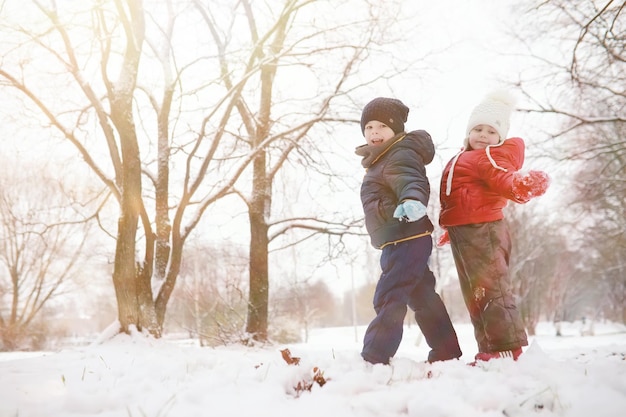 Los niños en el parque de invierno juegan