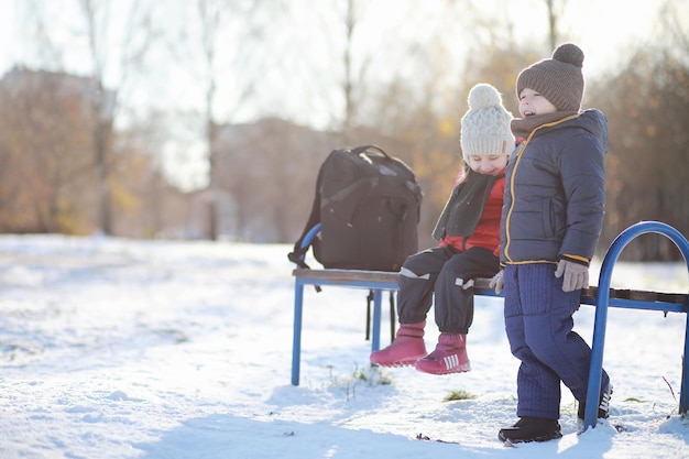 Los niños en el parque de invierno juegan