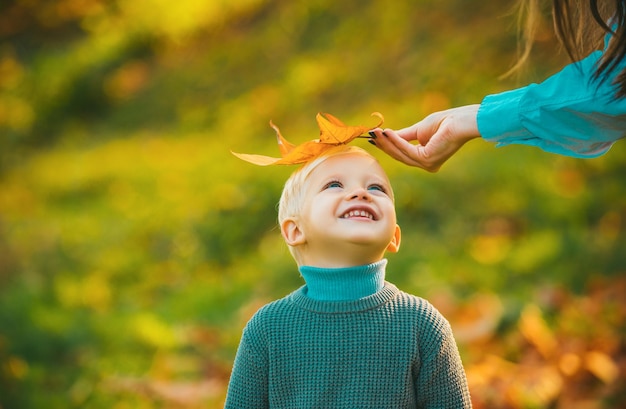 Foto niños en el parque de otoño sobre un fondo de hojas amarillas