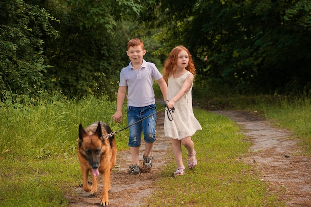 los niños pasean al perro en el parque