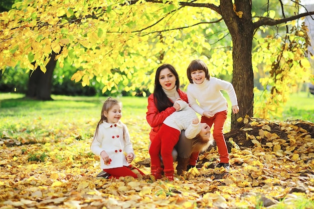 Niños a pasear por el parque de otoño. Caída de hojas en el parque. Familia. Otoño. Felicidad.