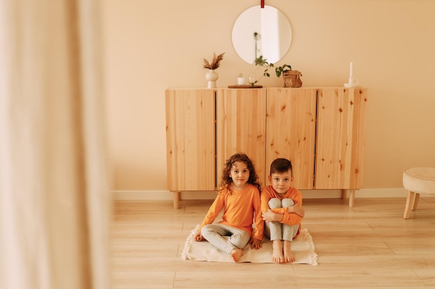 Foto niños pequeños amigos hermano y hermana en ropa de casa jugando juntos en la habitación de los niños en casa