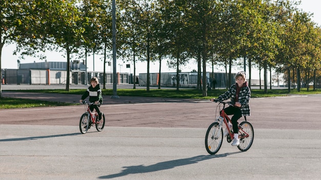 Niños pequeños en bicicleta afuera juntos