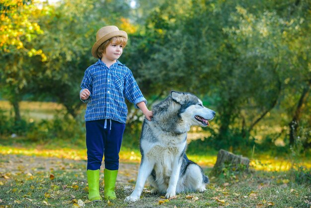 Niños pequeños caminando junto con su perro mascota al aire libre niños divirtiéndose perro mascota en el campo contra na