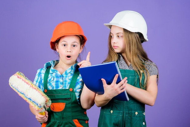 Niños pequeños en casco con tableta y rodillo. Día laboral. 1 de mayo. niñas pequeñas reparando juntas en el taller. Inspector capataz. Reparar. idea de ingeniería. mi idea es perfecta. déjame presentarte mi idea.