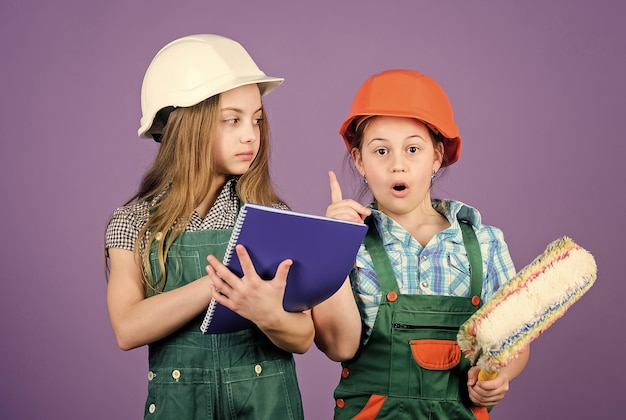 Niños pequeños con casco con tableta y rodillo Día del trabajo 1 de mayo Niñas pequeñas reparando juntas en el taller Inspector de capataz Idea de ingeniería de reparación Mi idea es perfecta Permítanme presentarles mi idea