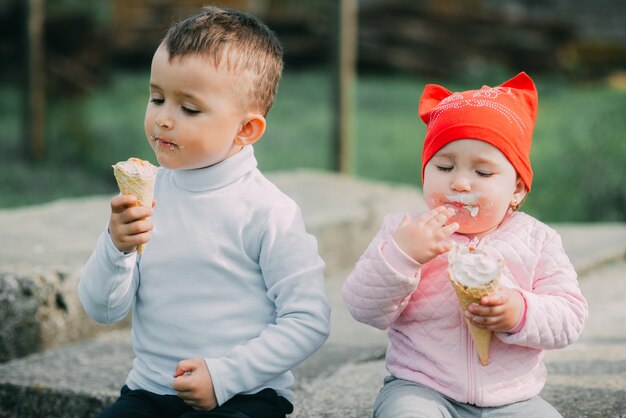 Niños pequeños comiendo helado al aire libre en el pueblo