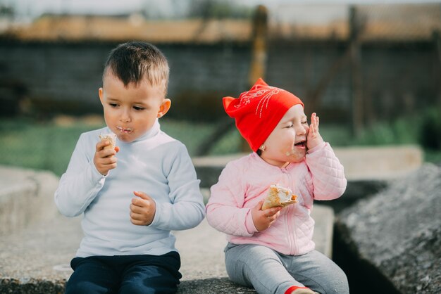 Niños pequeños comiendo helado al aire libre en el pueblo