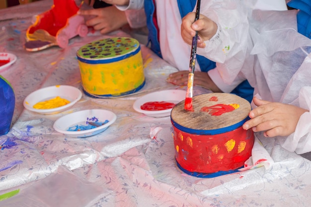 Niños pequeños decorando tambores hechos a mano