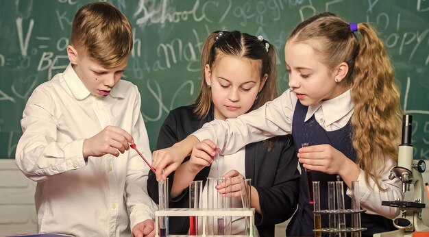 Niños pequeños Experimentos de biología de ciencia con microscopio Laboratorio microscopio y tubos de ensayo Ciencia química Científicos de niños pequeños ganando química en el laboratorio de la escuela Listos para el examen final