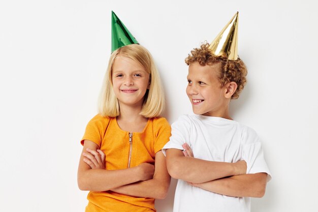 Niños pequeños en gorras multicolores cumpleaños vacaciones emoción estilo de vida inalterado