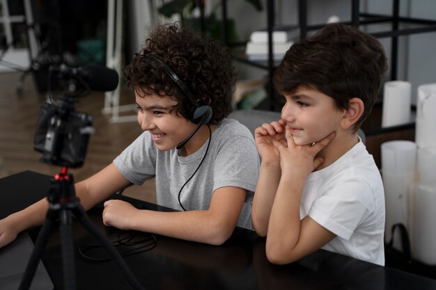 Foto niños pequeños haciendo streaming juntos en línea