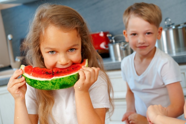 Niños pequeños, hermano y hermana comiendo sandía