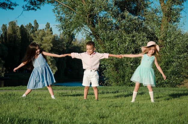 Los niños pequeños jugando en el césped. dos niñas y un niño