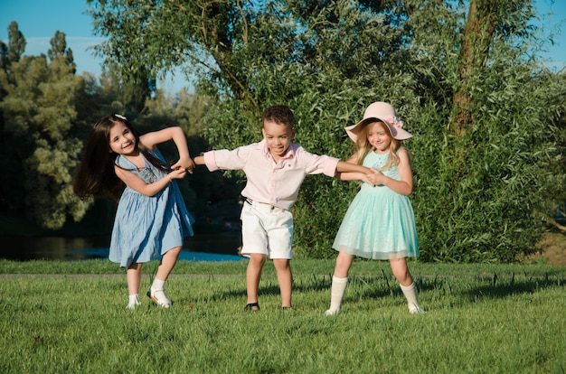 Los niños pequeños jugando en el césped. dos niñas y un niño