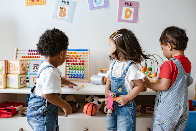 Foto niños pequeños jugando con juguetes educativos.