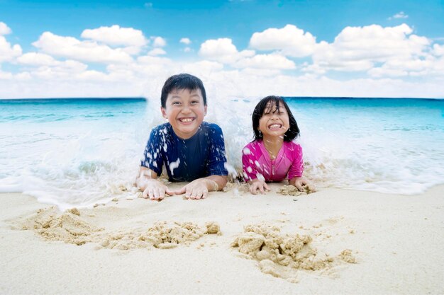 Niños pequeños jugando a las olas en la orilla