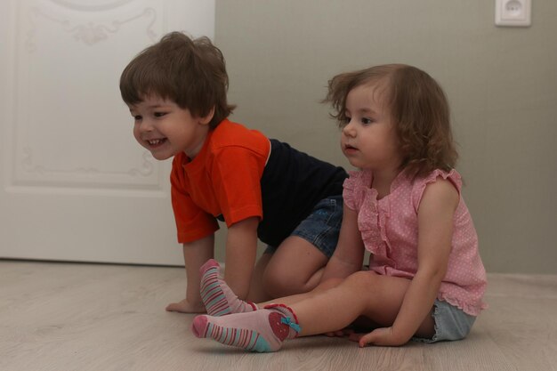 Niños pequeños jugando en el piso de una habitación