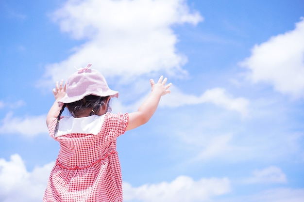 Los niños pequeños levantan los brazos hacia el cielo