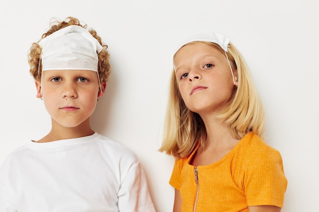 Niños pequeños con protección de mascarillas médicas que presentan un estilo de vida mueca inalterado