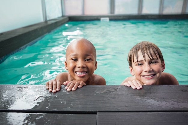 Niños pequeños sonriendo en la piscina