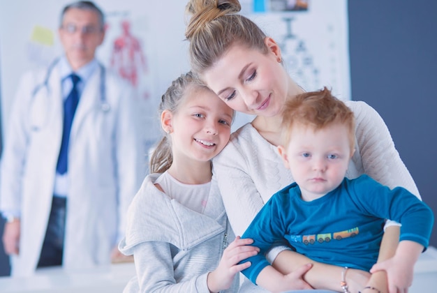 Niños pequeños con su madre en un médico en consulta