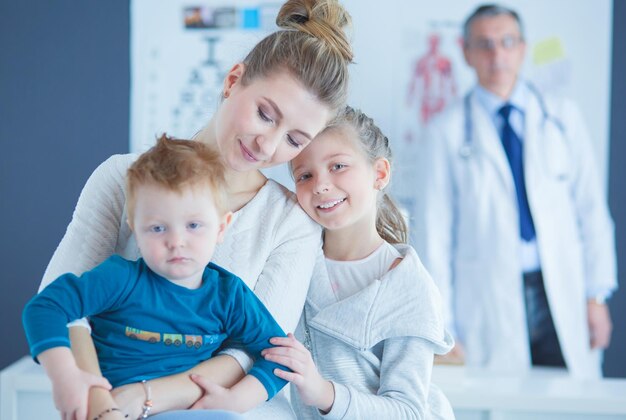 Niños pequeños con su madre en un médico en consulta