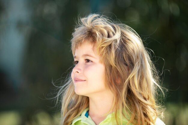 Los niños de perfil se enfrentan al retrato de un adorable niño pequeño en un parque de fondo verde en la naturaleza wow look portra