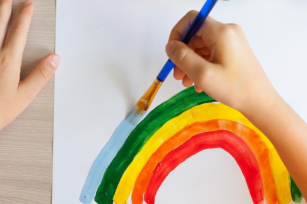 Foto niños pintando arco iris en acuarela en la mesa en casa artes y manualidades