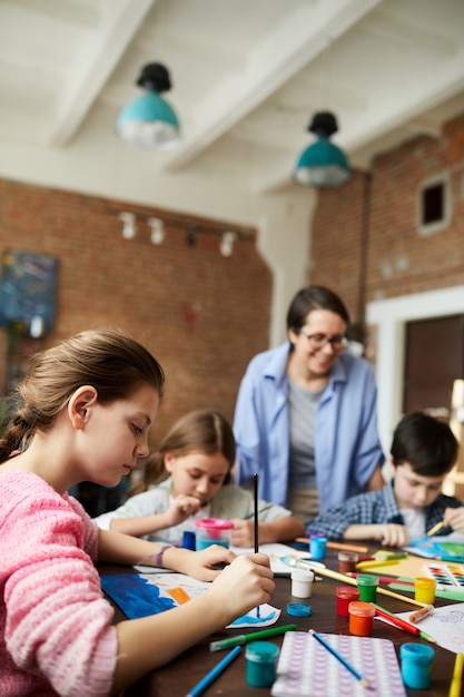 Foto niños pintando en clase de arte