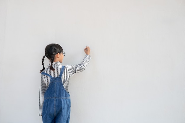 Niños pintando en la pared blanca