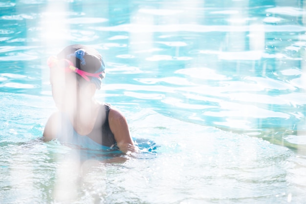 Foto niños en la piscina divirtiéndose.