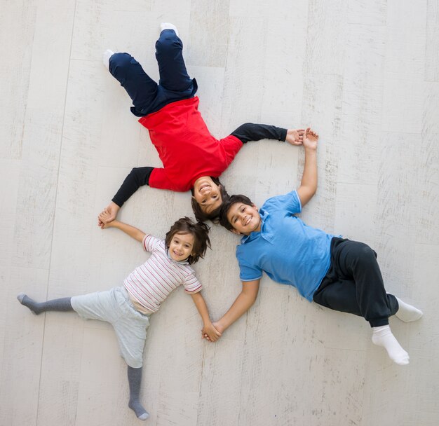 Niños en el piso juntos en la vista superior de la casa nueva