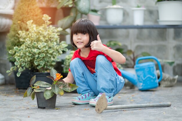 Niños plantando árboles con fondo de naturaleza, niña asiática feliz