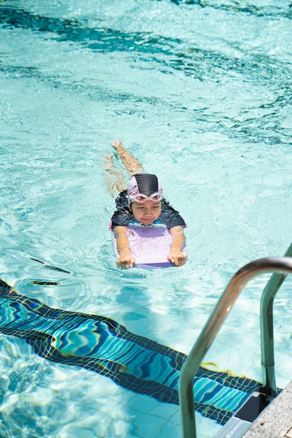 Los niños practican la natación en la piscina.