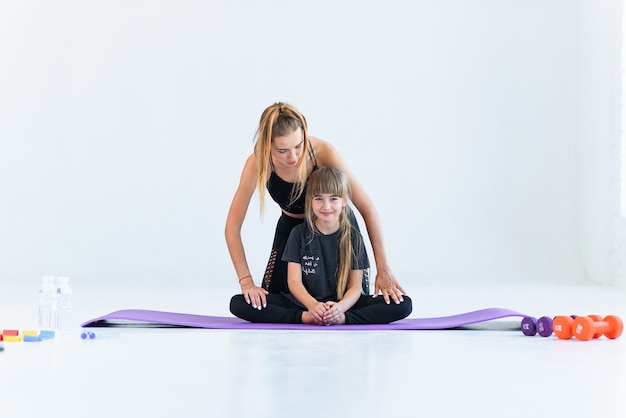 Niños practicando gimnasia y yoga con el maestro.