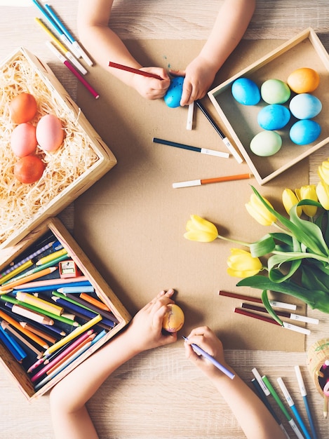 Los niños se preparan para la Pascua Niños pintando huevos de Pascua Fondo de Pascua vista plana endecha superior