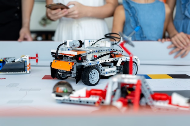 Los niños de primer plano controlan coches robots ensamblados a partir de un constructor programado en una computadora en una escuela de robótica