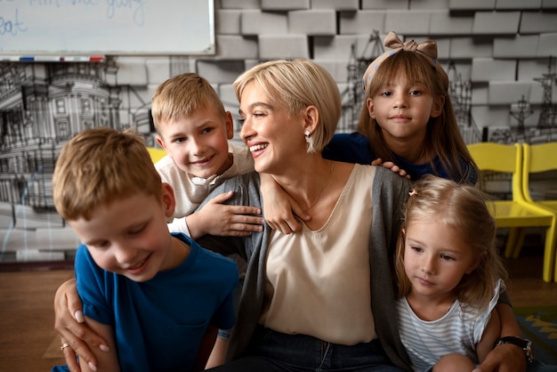 Foto niños y profesor sonriente de vista frontal