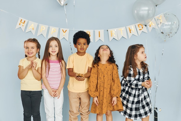 Los niños que celebran la fiesta de cumpleaños en el interior se divierten juntos