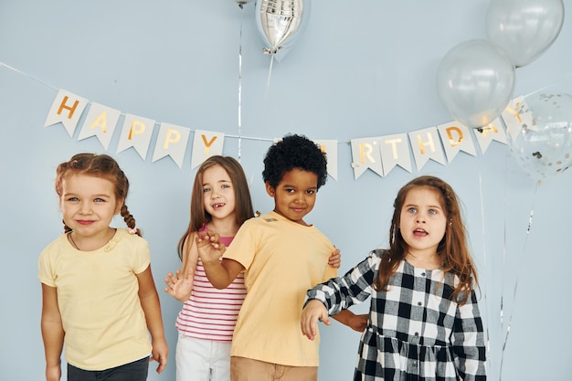 Foto los niños que celebran la fiesta de cumpleaños en el interior se divierten juntos